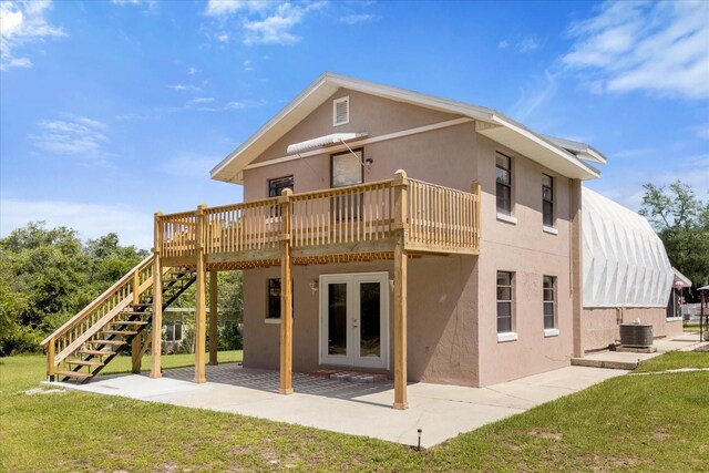 rear view of property with french doors, a yard, a patio area, and cooling unit