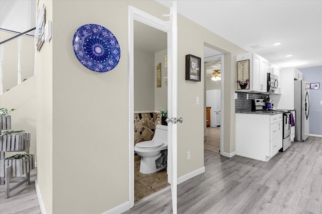 interior space featuring recessed lighting, baseboards, and light wood finished floors