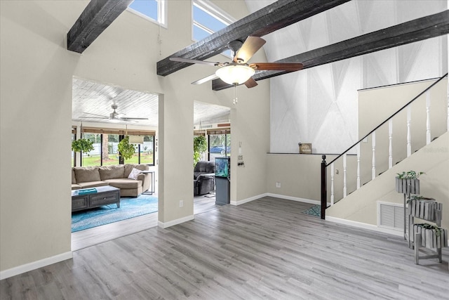 interior space with beamed ceiling, wood-type flooring, and ceiling fan