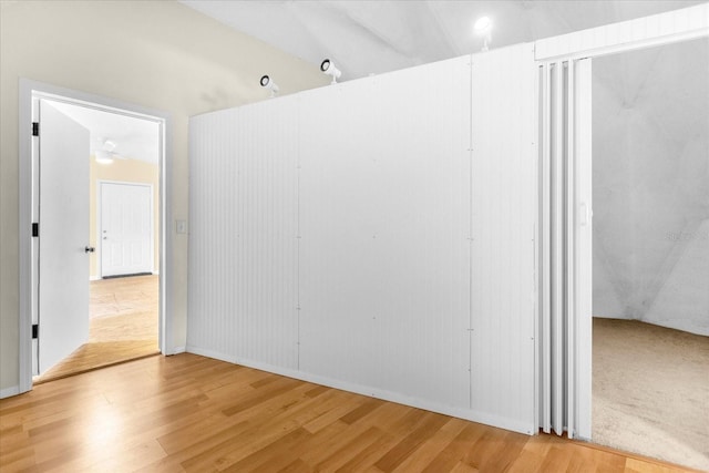 spare room featuring light carpet and vaulted ceiling