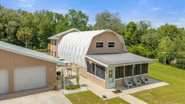 view of front of house featuring a sunroom, a front yard, and a garage