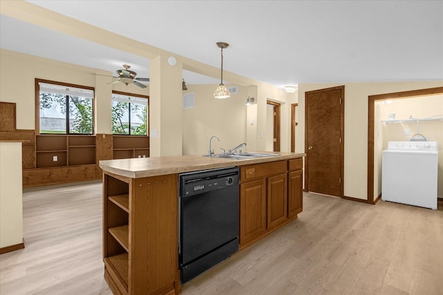 kitchen with washer / dryer, black dishwasher, a center island with sink, pendant lighting, and a sink