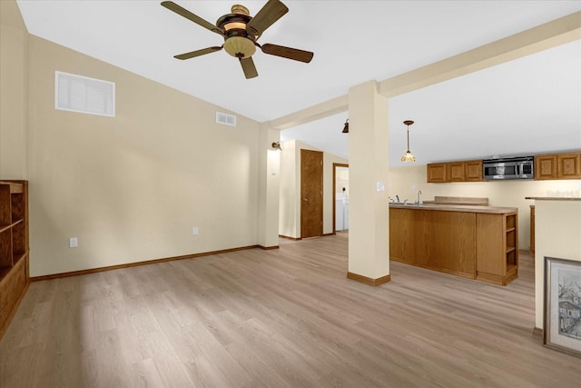 unfurnished living room with sink, ceiling fan, and light hardwood / wood-style floors