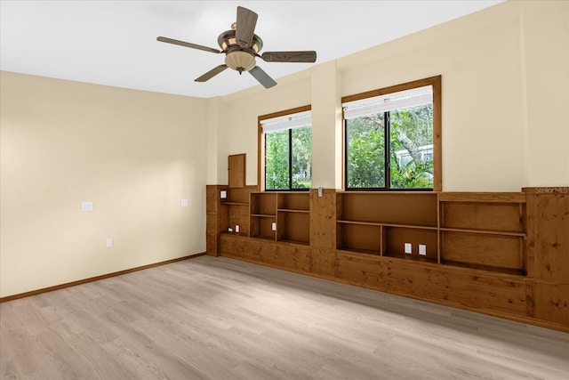 unfurnished room featuring light wood-type flooring, a ceiling fan, and baseboards