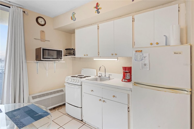 kitchen with white cabinets, sink, white appliances, and light tile patterned floors