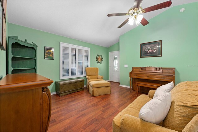 living room featuring ceiling fan, vaulted ceiling, and dark wood-type flooring