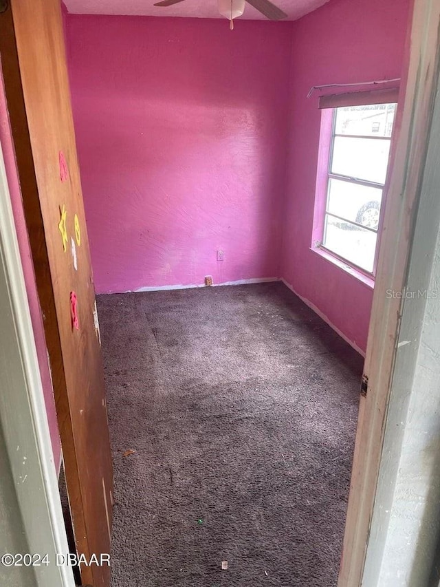 carpeted spare room with ceiling fan