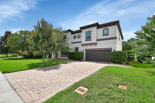 mediterranean / spanish-style house featuring a front lawn and a garage