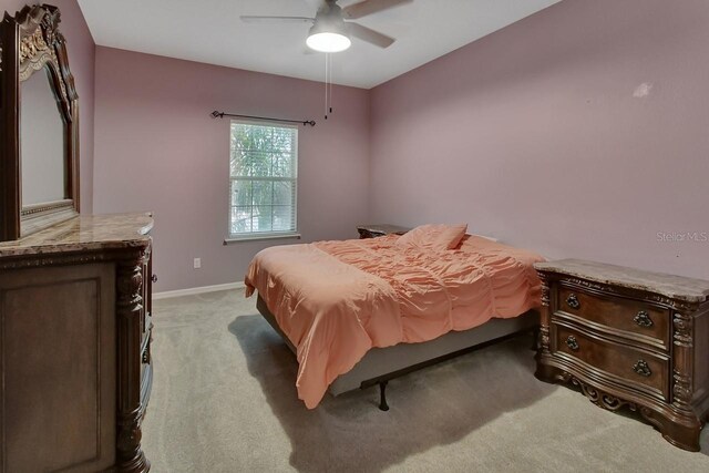 bedroom featuring ceiling fan and light carpet