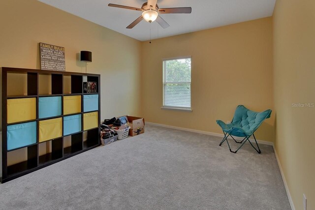 living area featuring ceiling fan and carpet