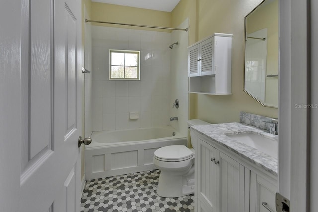 full bathroom featuring toilet, tiled shower / bath combo, vanity, and tile patterned flooring