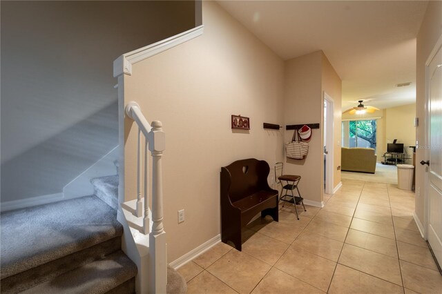 stairs with tile patterned floors and ceiling fan