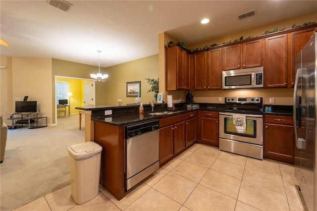 kitchen featuring a chandelier, light carpet, sink, kitchen peninsula, and stainless steel appliances