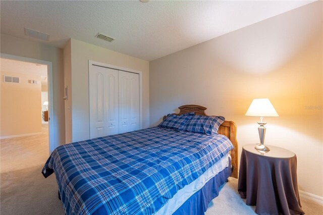 bedroom with light colored carpet and a closet