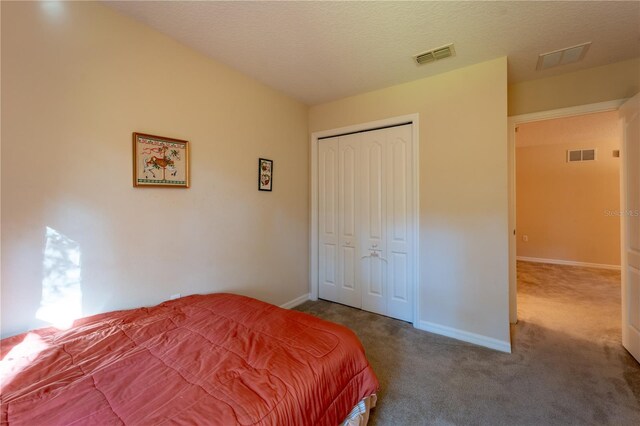 carpeted bedroom featuring a textured ceiling and a closet