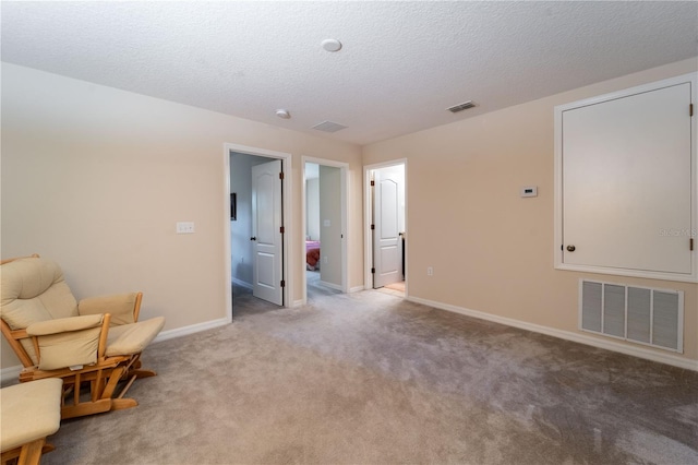 living area featuring carpet and a textured ceiling