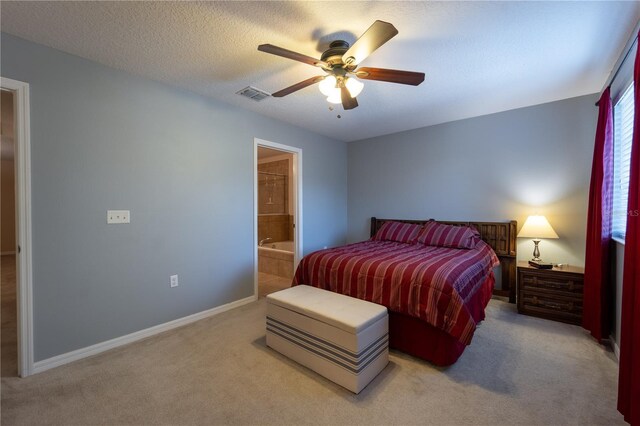 carpeted bedroom with ceiling fan, connected bathroom, and a textured ceiling