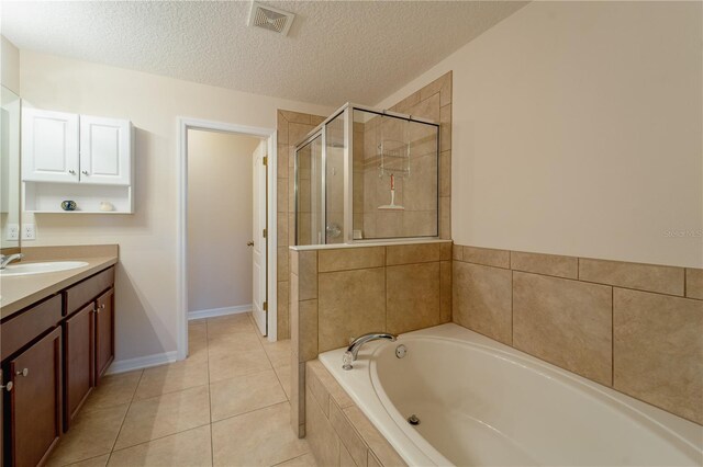 bathroom featuring independent shower and bath, tile patterned flooring, a textured ceiling, and vanity