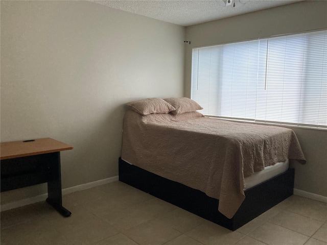 bedroom with light tile patterned floors and a textured ceiling