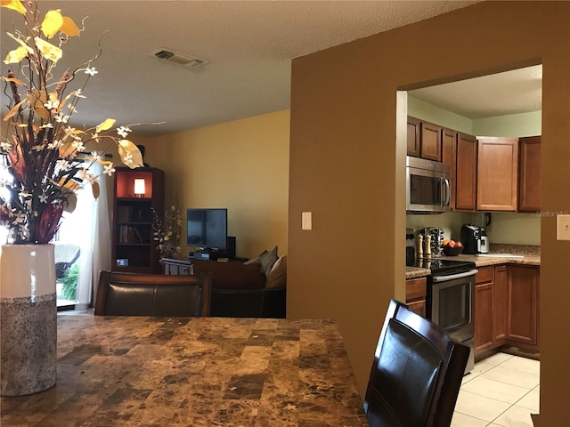 kitchen with light tile patterned floors and stainless steel appliances