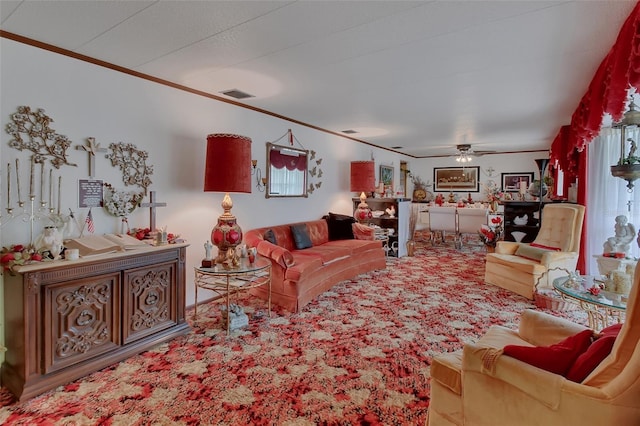 living room with ceiling fan, carpet, and ornamental molding