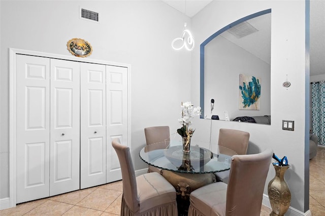 tiled dining space featuring vaulted ceiling