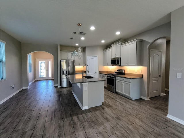 kitchen with sink, hanging light fixtures, an island with sink, and appliances with stainless steel finishes