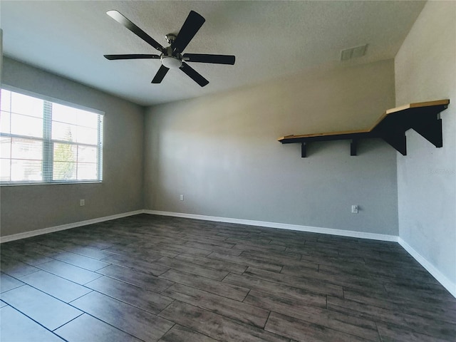 spare room featuring dark wood-type flooring and ceiling fan