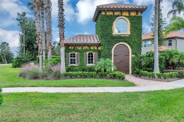 mediterranean / spanish home featuring a front yard