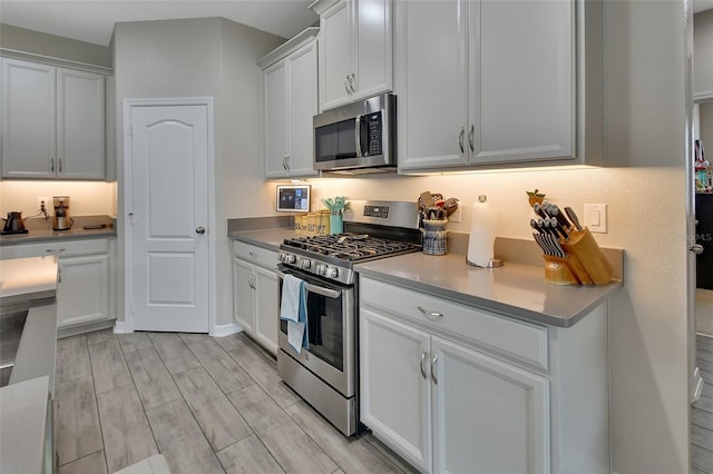 kitchen featuring white cabinetry, light wood-type flooring, and appliances with stainless steel finishes