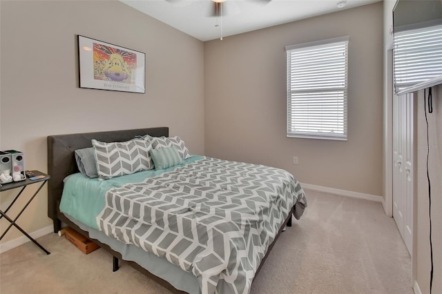 bedroom featuring light colored carpet, a closet, and ceiling fan