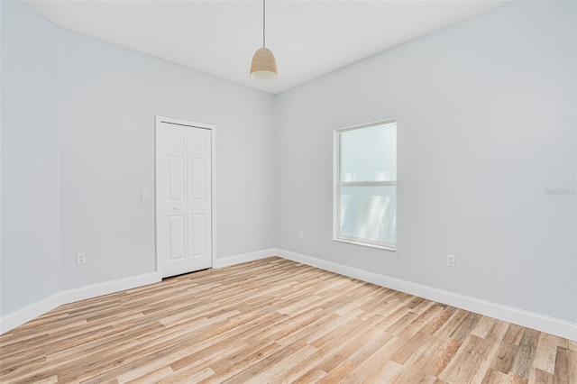 unfurnished room featuring baseboards and light wood finished floors