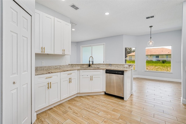 kitchen featuring stainless steel dishwasher, light wood-type flooring, a sink, and visible vents