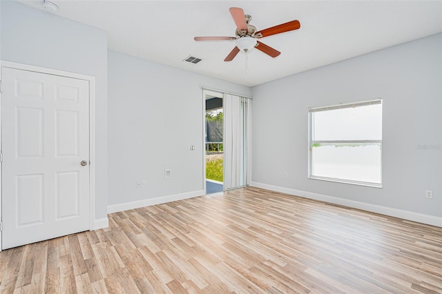 spare room with light wood-type flooring, baseboards, visible vents, and ceiling fan