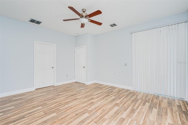 unfurnished room featuring light wood-style flooring, visible vents, ceiling fan, and baseboards