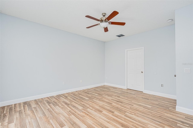 spare room featuring ceiling fan, light wood finished floors, visible vents, and baseboards