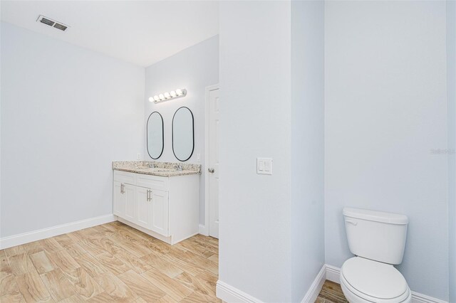 bathroom featuring visible vents, baseboards, and wood finished floors