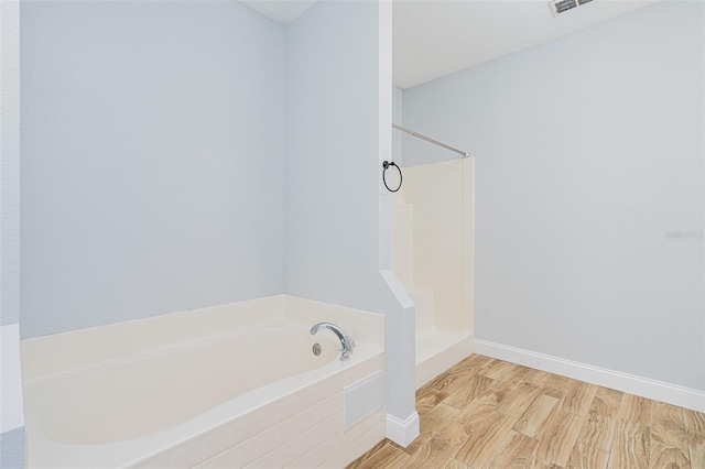 full bath with a garden tub, baseboards, walk in shower, and wood finished floors