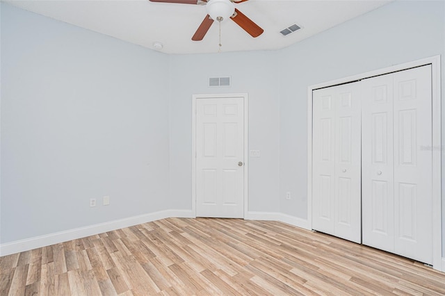 unfurnished bedroom with light wood finished floors, baseboards, visible vents, and a closet