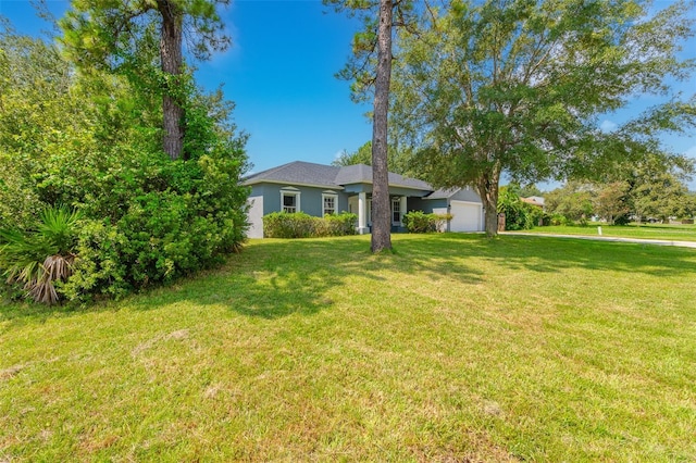 view of front of home with a garage, a front yard, and stucco siding