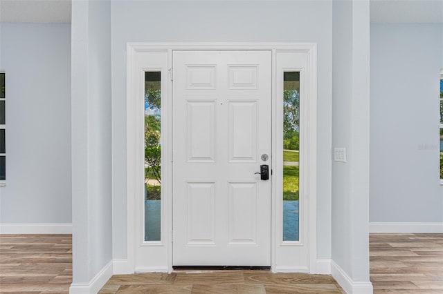 entryway with baseboards and wood finished floors