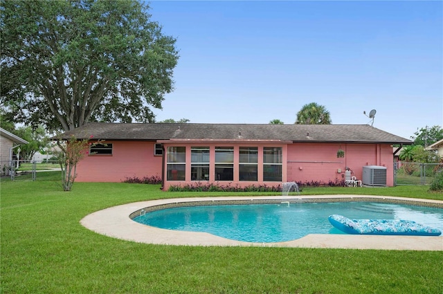 rear view of property featuring an outdoor pool, a yard, fence, and central AC unit