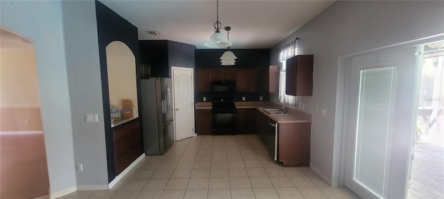 kitchen featuring light tile patterned floors, sink, stainless steel appliances, and decorative light fixtures