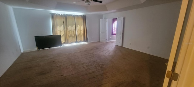 carpeted spare room with ceiling fan and a tray ceiling