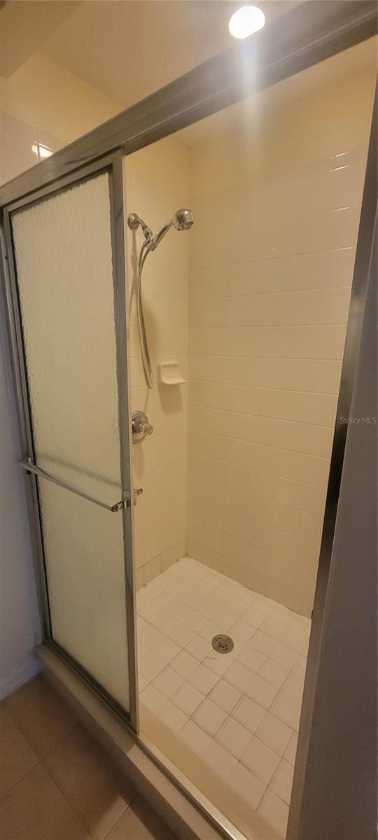 bathroom with tile patterned floors and a shower with shower door