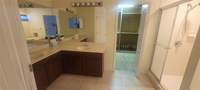 bathroom with double vanity, tile patterned floors, and a shower with shower door