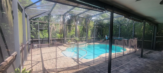 view of swimming pool with glass enclosure and a patio area