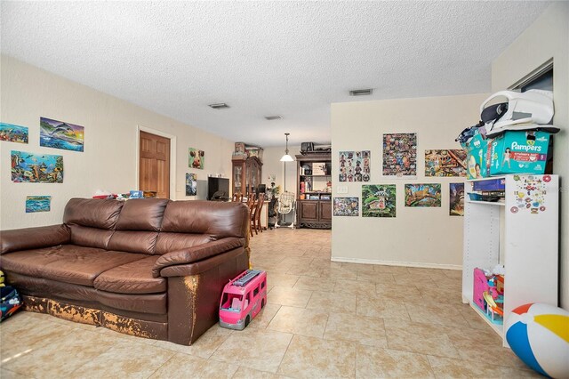 tiled living room featuring a textured ceiling