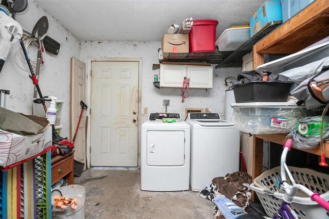 washroom with washer and dryer and cabinets