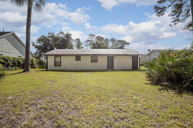 rear view of property featuring a lawn